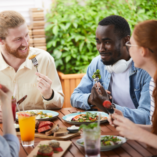 Junge Menschen sitzen zusammen und essen